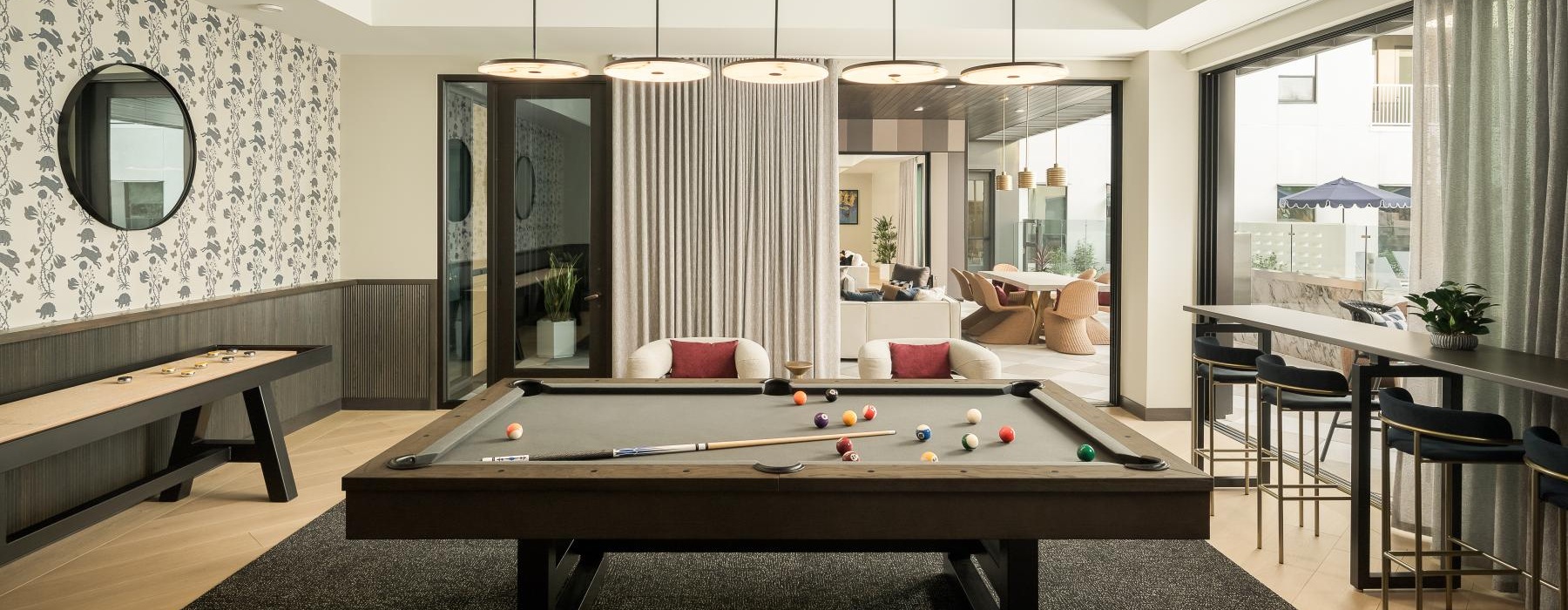 a room with a pool table and chairs